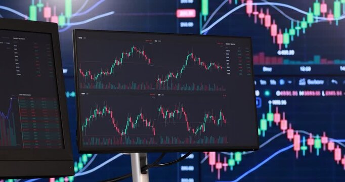 Multiple computer monitors display complex financial data. Glowing screens showcase vibrant red and green candlestick charts, perfectly illustrating live market trends
