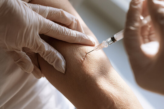 First-person POV close-up of a hypodermic needle injection into a forearm
