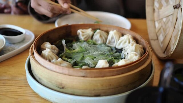 Enjoying dumplings in a bamboo steamer at a restaurant
