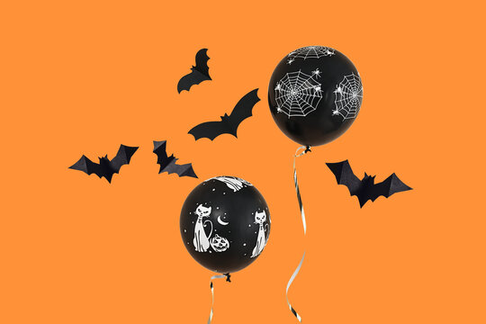 Halloween. Balloons with Halloween designs float against a vibrant orange backdrop