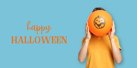 Fototapeta premium Halloween. Child holds cheerful Halloween balloon while smiling in vibrant setting
