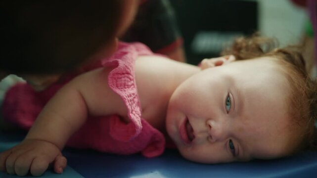Baby with Down syndrome lying prone on a mat, working on early intervention and physical therapy for development
