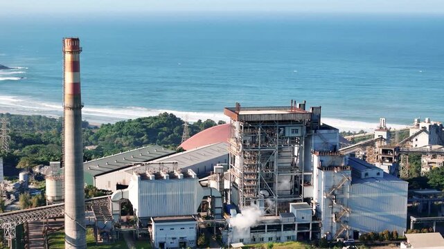 Large coastal power facility with smokestack symbolizing energy industry, electricity generation, industrialization, and environmental concerns.
