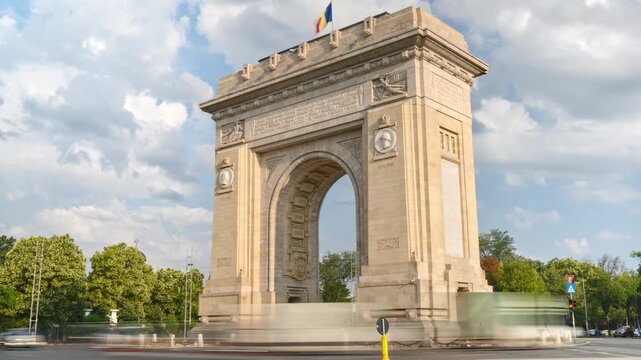 Arc de triomphe monument in bucharest with blurred traffic moving in time lapse footage.