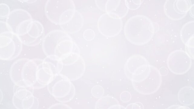 Elegant white iridescent bokeh background with soft floating glowing circles and particles. This seamless motion graphic loop is perfect for clean wedding and cosmetic video designs.