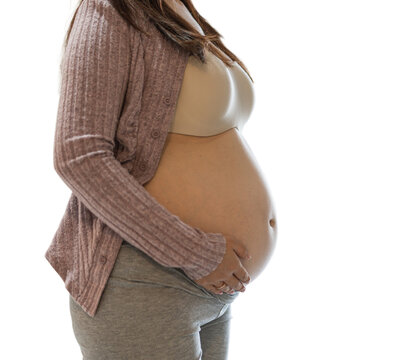 Side view of a bare pregnant belly with a cardigan and both hands cradling it, isolated on a transparent background.