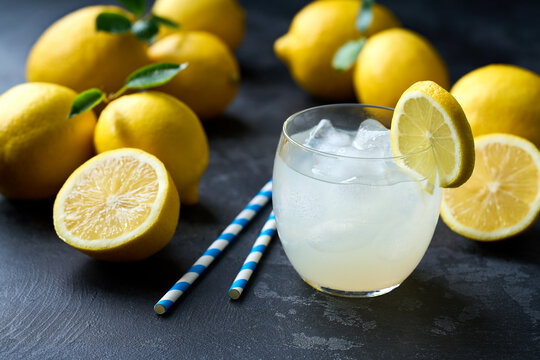 Refreshing homemade summer lemonade in glass with ice on a black table, selective focus. Cold refreshing lemonade .