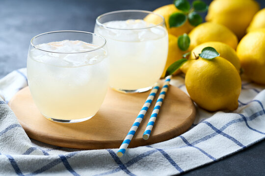 Freshly made lemonade with ice on dark table, selective focus, cold refreshing drink in summer .