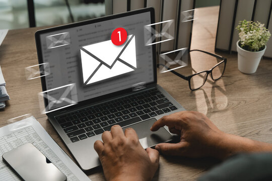 Hands checking email notification on laptop with floating mail icons, showing new email alert, inbox message update, digital communication, online notification, office workspace.