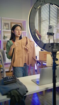 Asian woman Gen Z live streaming fashion clothing sales and looking at camera,social commerce influencer web broadcasting,e-business,e-commerce on entrepreneur,order confident,new business for gen Z
