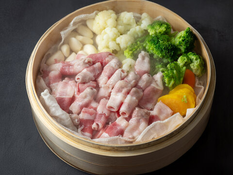 Beef brisket and various vegetables in a bamboo steamer