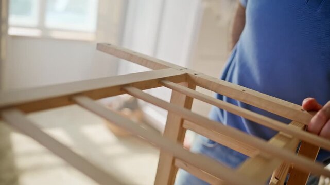 Father assembling wooden crib nursery. Couple fitting mattress baby cot home.
