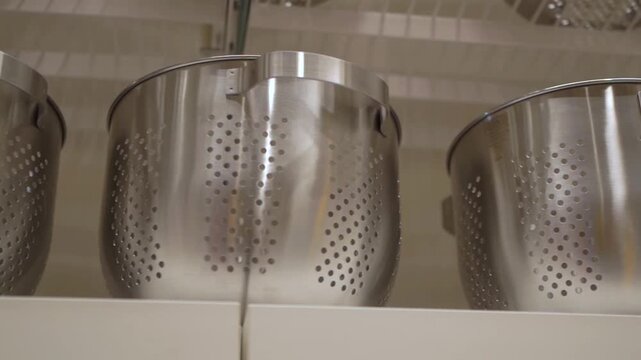 A deep, pot-shaped colander in a shop window.