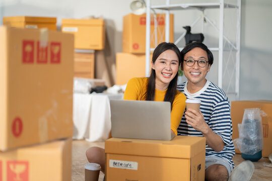 Asian couple of home owners discussing new renovate home,wood samples,moving box,interior design improvement,new design for new home.asian chooses a sample floor for his new apartment
