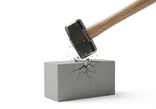 Sledgehammer striking and cracking a grey concrete block
