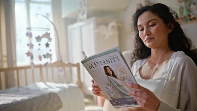 Mother-to-be reading maternity magazine nursery. Pregnant woman resting chair.