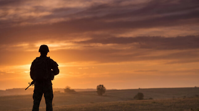 Silhouette of armed soldier at golden sunset