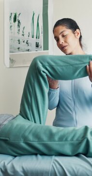 Clinic, woman and leg stretch for physio, muscle tension relief or functional screening for hip. Rehabilitation, worker and client with knee bend assistance, physical therapy and mobility assessment