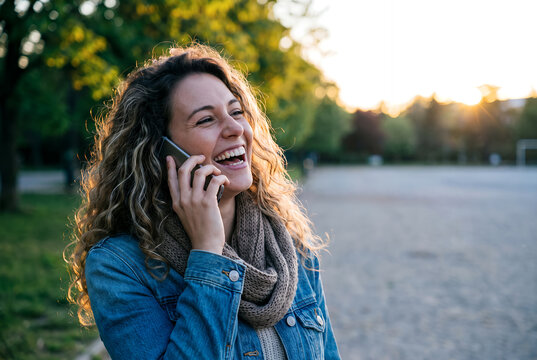 Woman in leather jacket gazing toward horizon in rural field