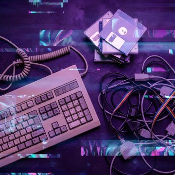Retro computer keyboard and floppy disks with digital glitch effect on dark background