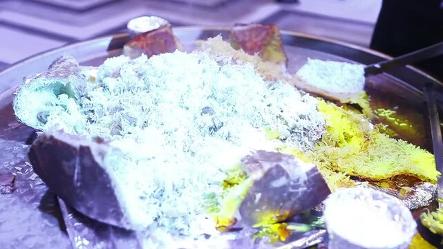 Chef serving steaming hot traditional shah plov with rice and meat on a plate during a fiery tray presentation. Outstanding oriental culinary masterclass and luxury catering for festive banquets.