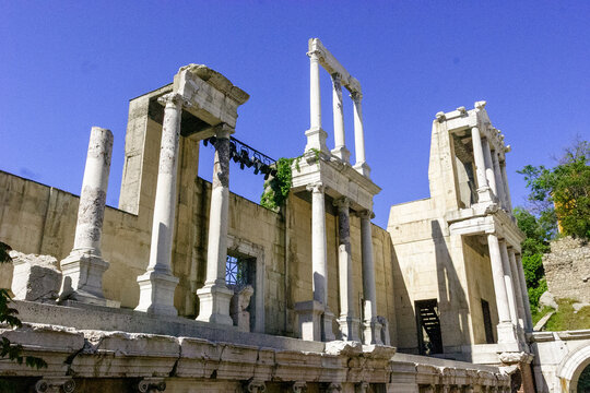 The Ancient Roman Theatre of Philippopolis in Plovdiv, Bulgaria, under a clear blue sky.