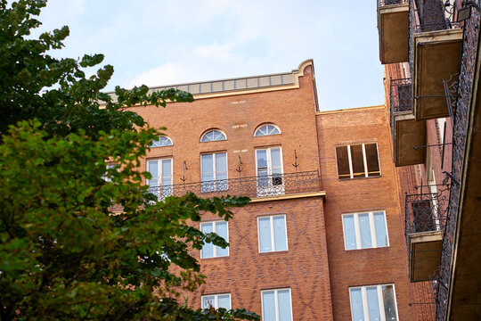 Red Brick Building with Balconies and Arched Windows
