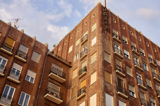 Red brick apartment building facade with balconies