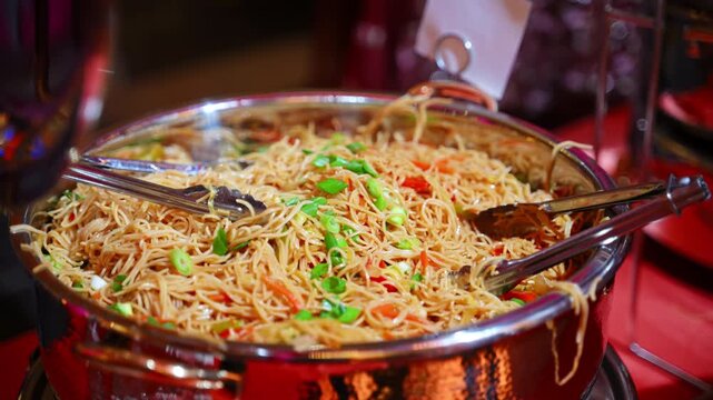 Close up of big pot with pasta and veggies at a food station during a banquet, corporate event, or private celebration.