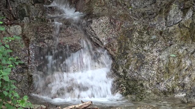 Clear Waterfall and Water Splash Flowing Down Rocky Cliff