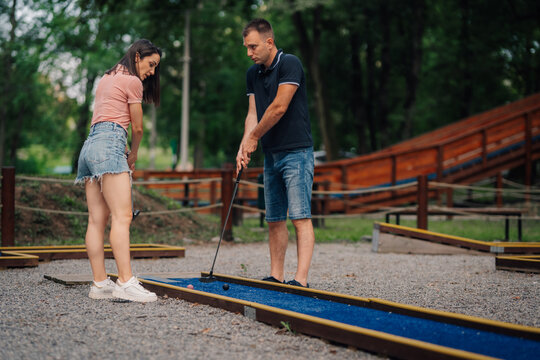 Couple enjoying a game of mini golf outdoors