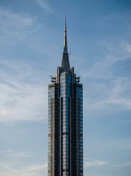 Modern glass skyscraper spire against clear blue sky with copy space . Generative AI