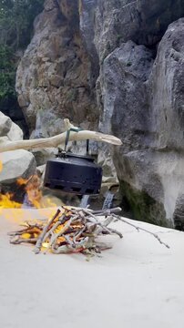 Serene Camp Life Aesthetic: Kettle on a Campfire in a Pristine Rocky Riverbed