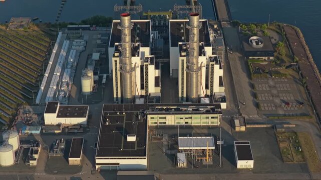 Aerial perspective of a modern combined cycle gas turbine power plant. Industrial facility generating electricity near a body of water