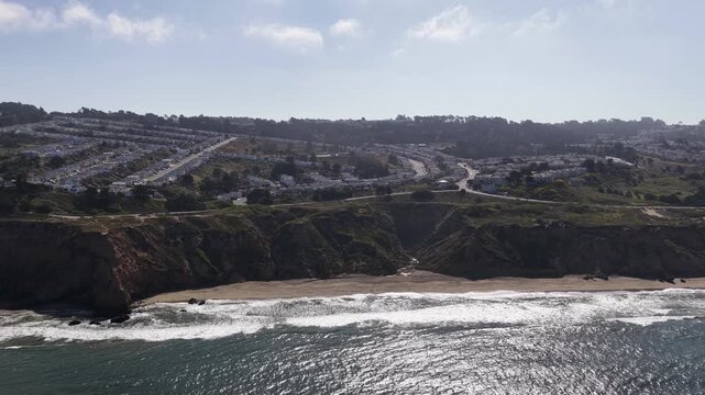 Aerial drone footage of Mussel Rock Park beach and the Daly City coast reveals rugged cliffs, Pacific Ocean waves, rocky shoreline, and expansive coastal scenery. Drone pull out shot