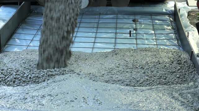 Wet concrete pouring into foundation formwork