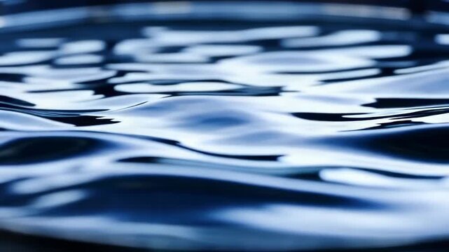 Close-up sequence of rippling water surface with reflections, showcasing the dynamic movement and texture of liquid in a shallow basin under natural light