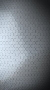 A monochrome hexagon membrane catches soft directional light across its surface in this vertical loop, giving a sleek neutral backdrop for corporate and tech presentations.