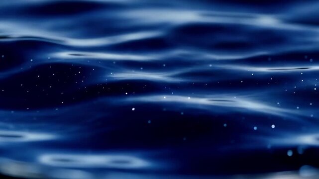 Dark blue water surface with gentle ripples and sparkling reflections, showcasing the dynamic movement of water in a serene aquatic environment