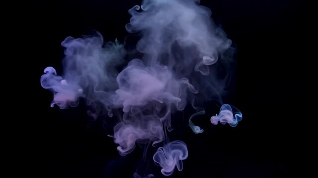 Colorful smoke wisps in various shapes and forms gradually disperse against a dark background, creating a mesmerizing visual flow of vibrant hues and ethereal patterns
