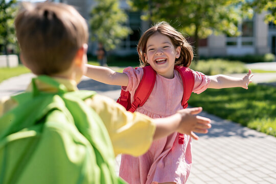 Young girl joyfully runs toward a friend under the warm sun in a lively park setting Generative AI