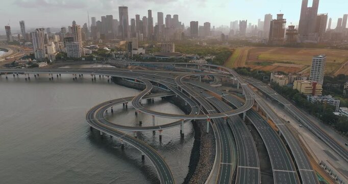 Morning view of the Mumbai Coastal Road in Maharashtra, India, famously known as the 'City of Dreams.' The scene captures a multi-level interchange roadway. A complex road network and urban designs.