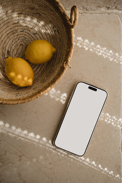 Mobile Phone Mockup Beside Woven Basket With Fresh Yellow Lemons