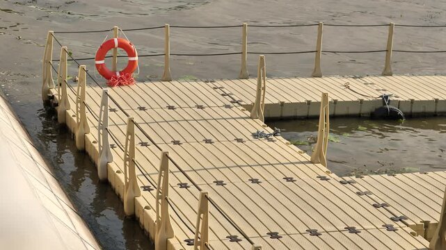 Modular plastic floating dock with lifebuoy, safety on a calm lake water surface