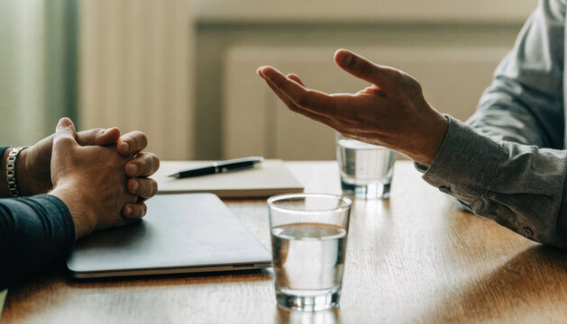 Business meeting handshake negotiation interview discussion teamwork collaboration office coworker agreement table glass water laptop notebook professional conversation job human hand manager