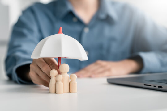 Life insurance concept. family protected under umbrella on policy documents. health coverage, beneficiaries, financial security planning.