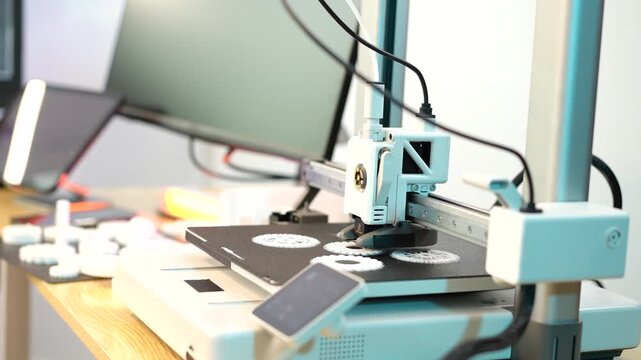 Desktop 3d printer creating small parts on a workbench in a bright workshop, showing modern technology, prototyping and home manufacturing.