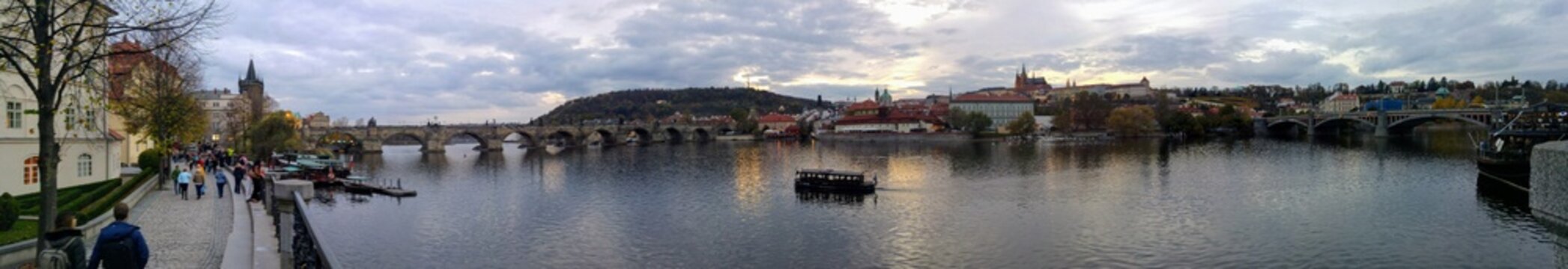 Prague panorama with Charles Bridge, Vltava River, and castle hill at dusk