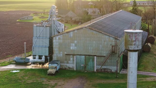 Morning aerial reveals Soviet farm relics beside a modern grain dryer in Latvia