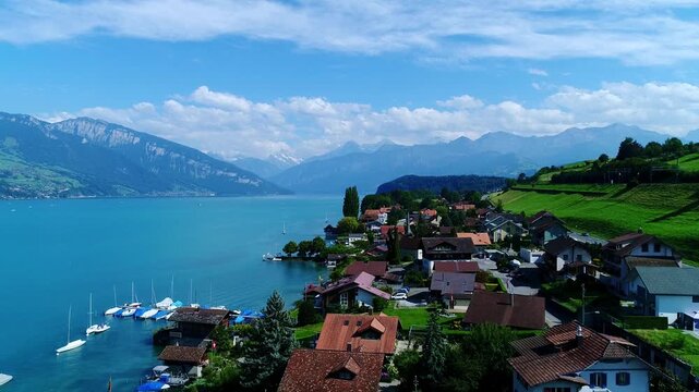 Turquoise Lake Thun meets green hills and Alpine homes beneath majestic peaks